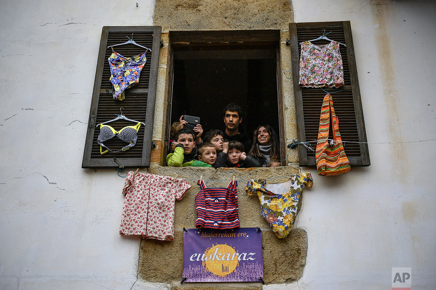  In this Monday, Jan. 27, 2020 photo, residents look from a window as ''Joaldunaks'' march along the street taking part in a Carnival in the small Pyrenees village of Ituren, northern Spain.  (AP Photo/Alvaro Barrientos) 