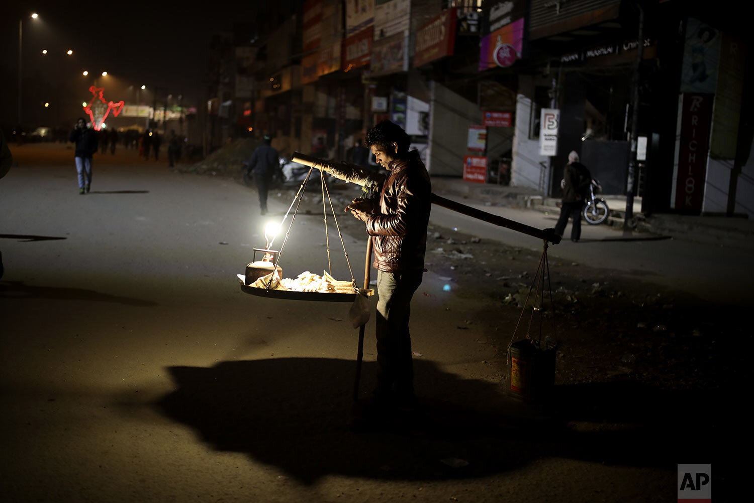  A roadside snack vendor waits for customers near a protest site against a new citizenship law that opponents say threatens India's secular identity, at Shaheen Bagh neighborhood of New Delhi, India, Saturday, Jan. 18, 2020. (AP Photo/Altaf Qadri) 
