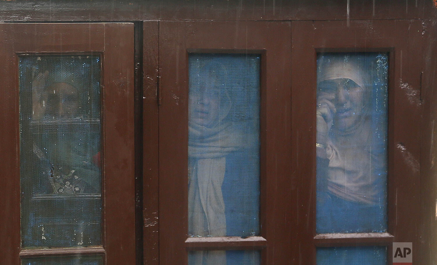  Kashmiri women watch the funeral of top rebel commander Umar Fayaz in the village of Tral, south of Srinagar, Indian controlled Kashmir, Monday, Jan. 13, 2020. (AP Photo/Mukhtar Khan) 