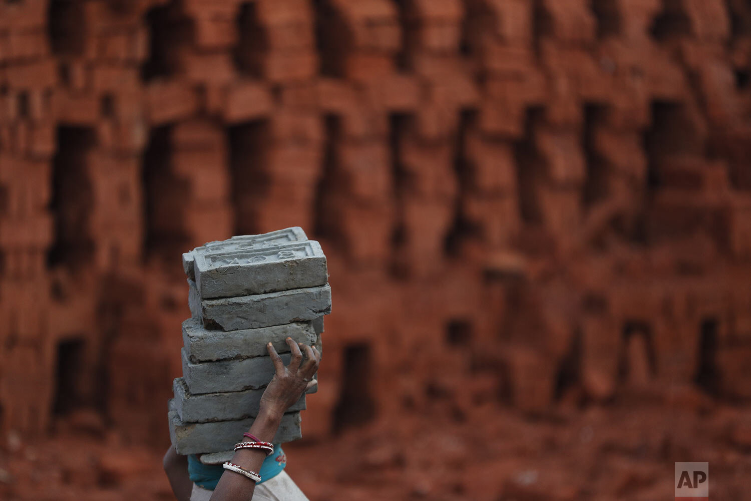  A Indian migrant woman worker carries bricks at a brick factory on the outskirts of Kathmandu, Nepal, Thursday, Jan. 9, 2020. (AP Photo/Niranjan Shrestha) 