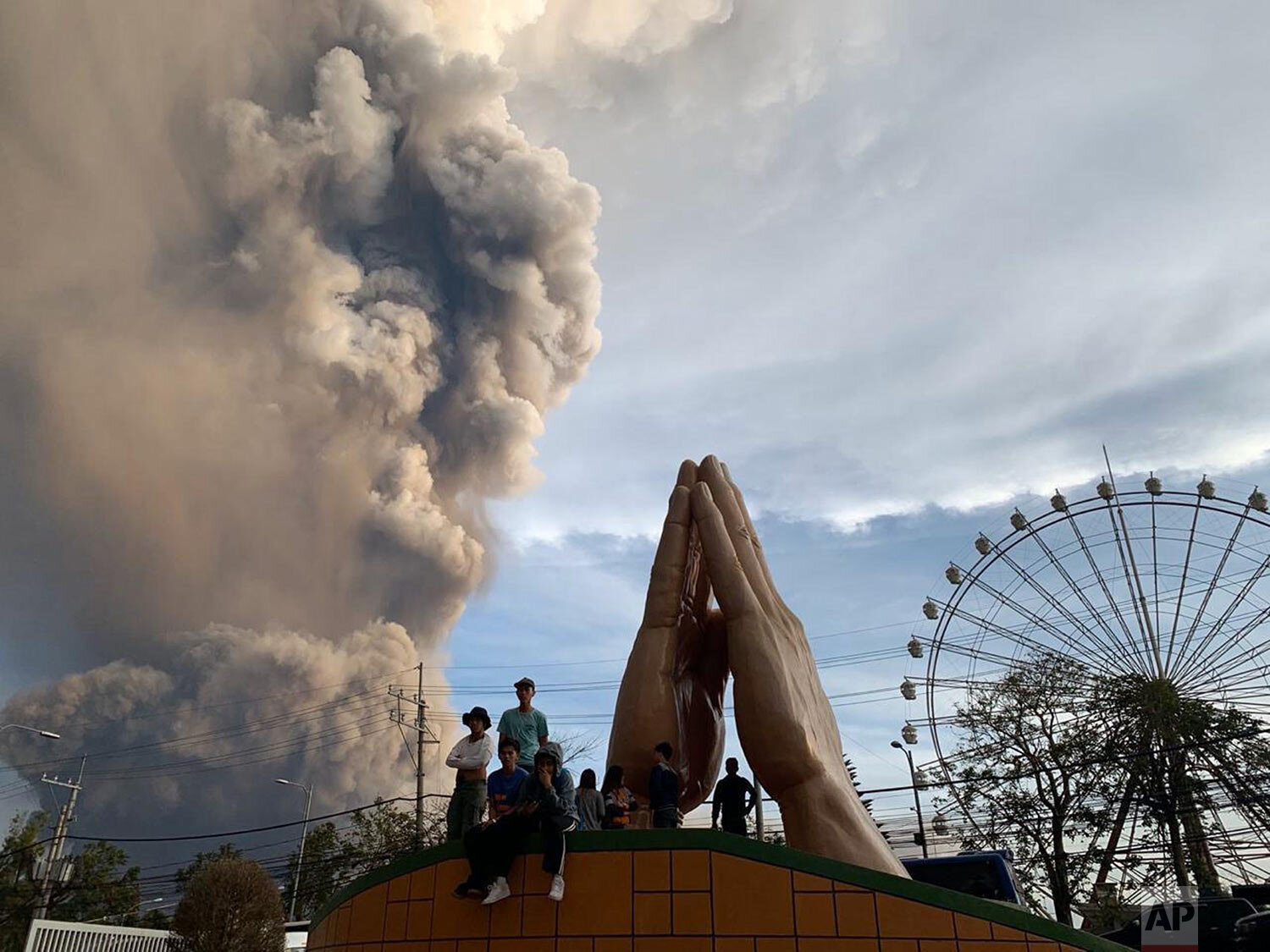  People watch as the Taal volcano spews ash and smoke during an eruption in Tagaytay, Cavite province south of Manila, Philippines, Sunday, Jan. 12, 2020. (AP Photo/Bullit Marquez) 
