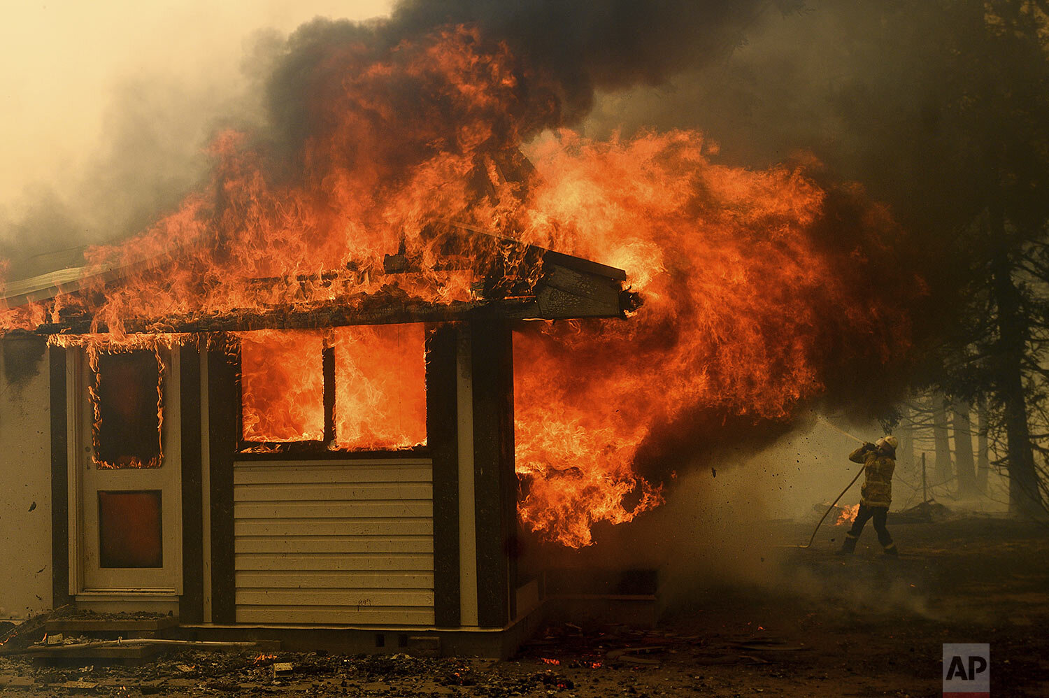  A firefighter battles the Morton Fire as it consumes a home near Bundanoon, New South Wales, Australia, Thursday, Jan. 23, 2020. (AP Photo (AP Photo/Noah Berger) 