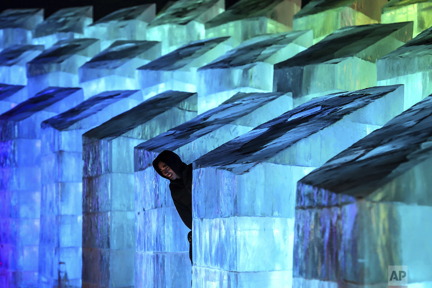  A  visitor looks at an ice sculpture on the opening night of the Harbin International Ice and Snow Festival in Harbin in northeastern China's Heilongjiang Province, Sunday, Jan. 5, 2020.  (Chinatopix via AP) 