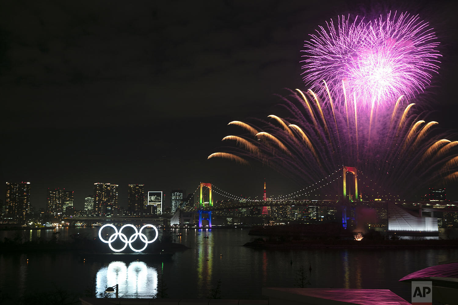  Fireworks light up the sky near the illuminated Olympic rings during a ceremony held to celebrate the 6-months-to-go milestone for the Tokyo 2020 Olympics, in the Odaiba district of Tokyo, Friday, Jan. 24, 2020. (AP Photo/Jae C. Hong) 