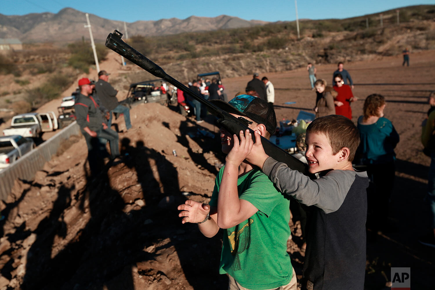  Boys point an unloaded gun at the sky as they play in La Mora, Mexico, one day before the expected arrival of Mexican President Andrés Manuel López Obrador, Saturday, Jan. 11, 2020.  (AP Photo/Christian Chavez) 