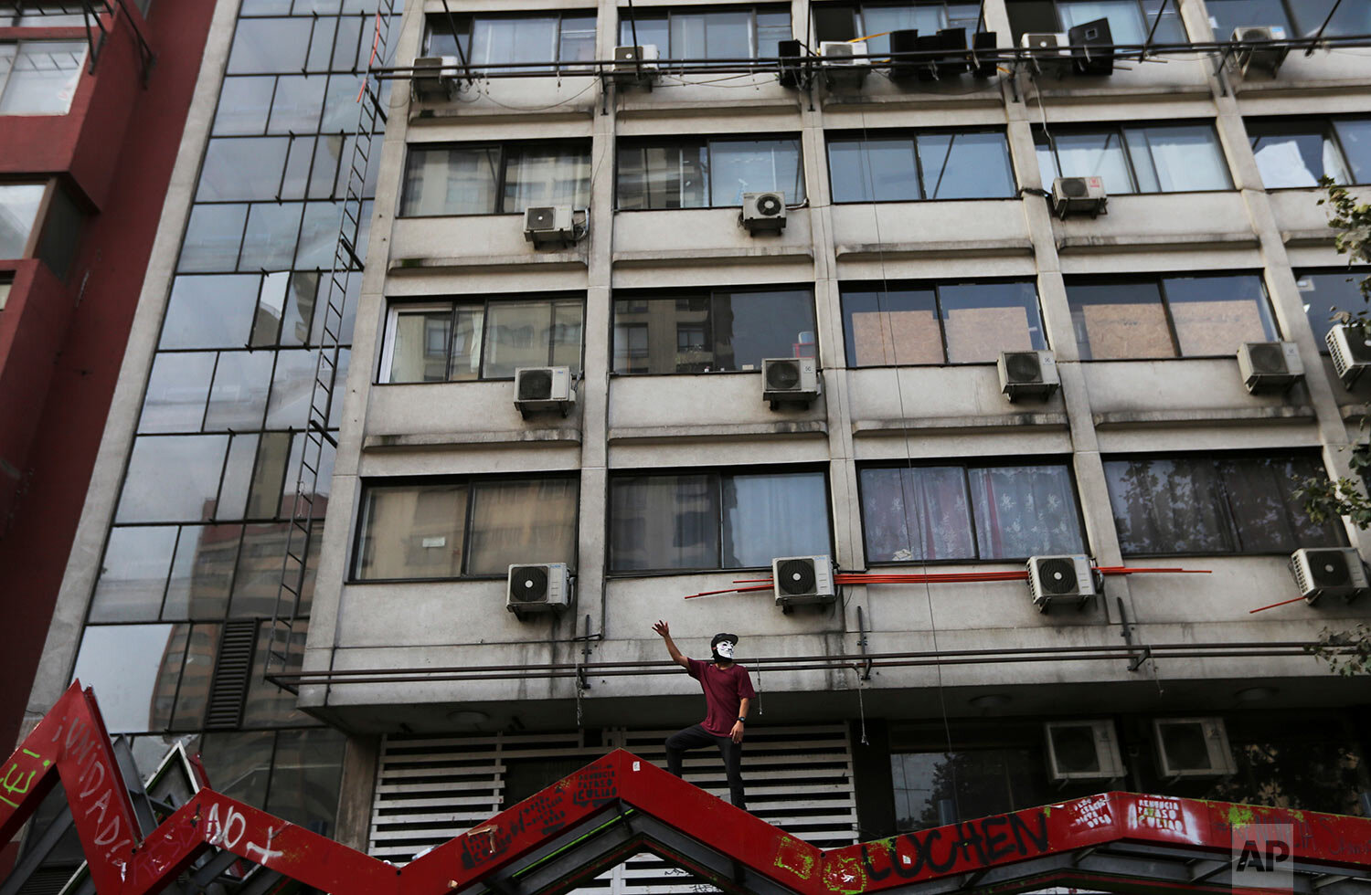  An anti-government demonstrator shouts slogans against Chile's President Sebastian Pinera from atop a destroyed bus station in Santiago, Chile, Friday, Jan. 17, 2020. (AP Photo/Fernando Llano) 