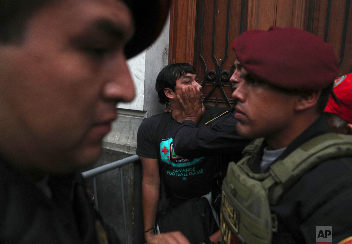  A supporter of Keiko Fujimori, the daughter of Peru's former President Alberto Fujimori and opposition leader, is held back by police officers outside a courtroom in Lima, Peru, Tuesday, Jan. 28, 2020. (AP Photo/Martin Mejia) 