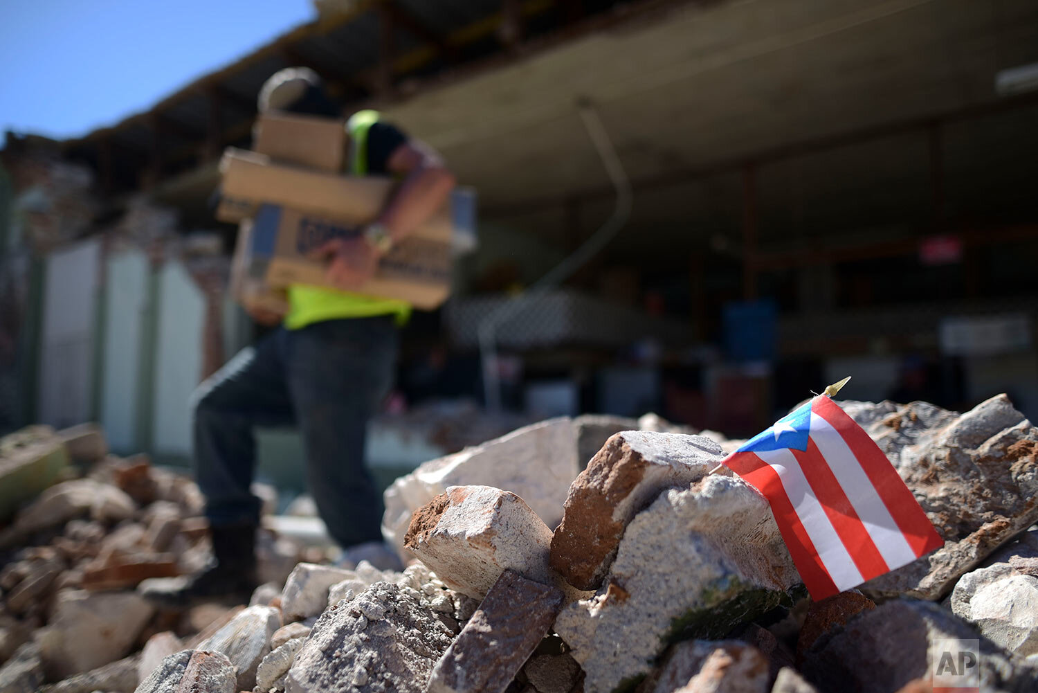  A Puerto Rican flag hangs within the rubble, after it was placed there where store owners and family help remove supplies from Ely Mer Mar hardware store, which partially collapsed after an earthquake struck Guanica, Puerto Rico, Tuesday, Jan. 7, 20