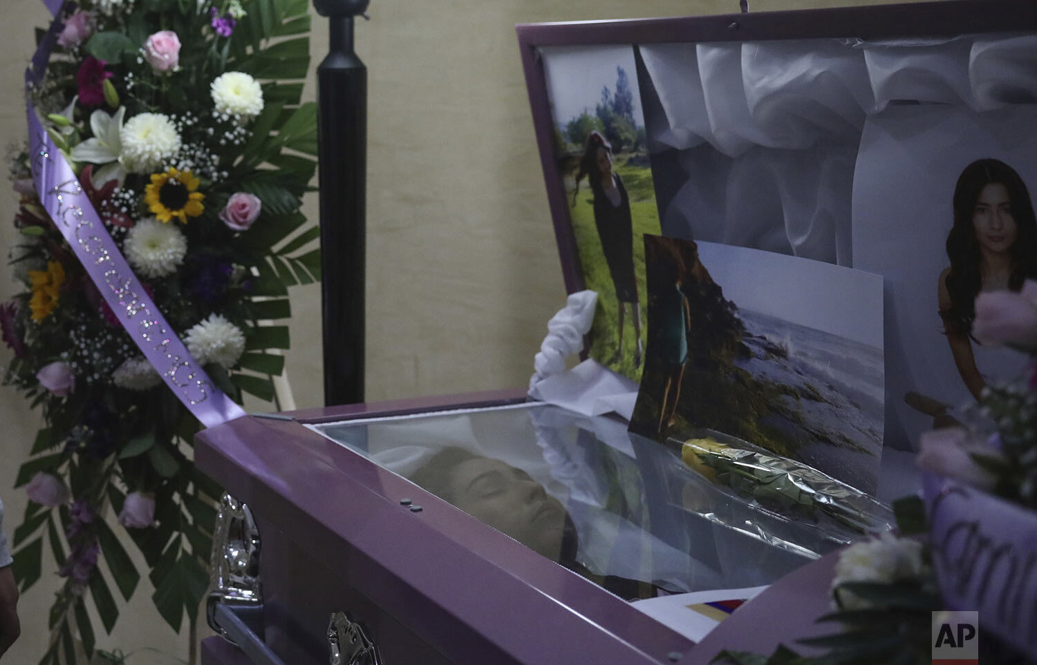  Flowers and photographs decorate the open casket of slain woman Marbella Valdez during her wake at a funeral home in Tijuana, Mexico, Thursday, Feb. 13, 2020. (AP Photo/Emilio Espejel) 