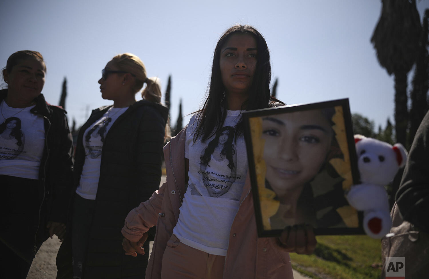  Marbella Valdez's friends, wearing T-shirts featuring her portrait, hold hands and pray during her burial at a cemetery in Tijuana, Mexico, Friday, Feb. 14, 2020. (AP Photo/Emilio Espejel) 