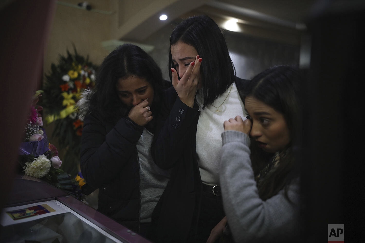  Mourners of slain woman Marbella Valdez grieve over her casket during her wake at a funeral home in Tijuana, Mexico, Friday, Feb. 14, 2020. (AP Photo/Emilio Espejel) 