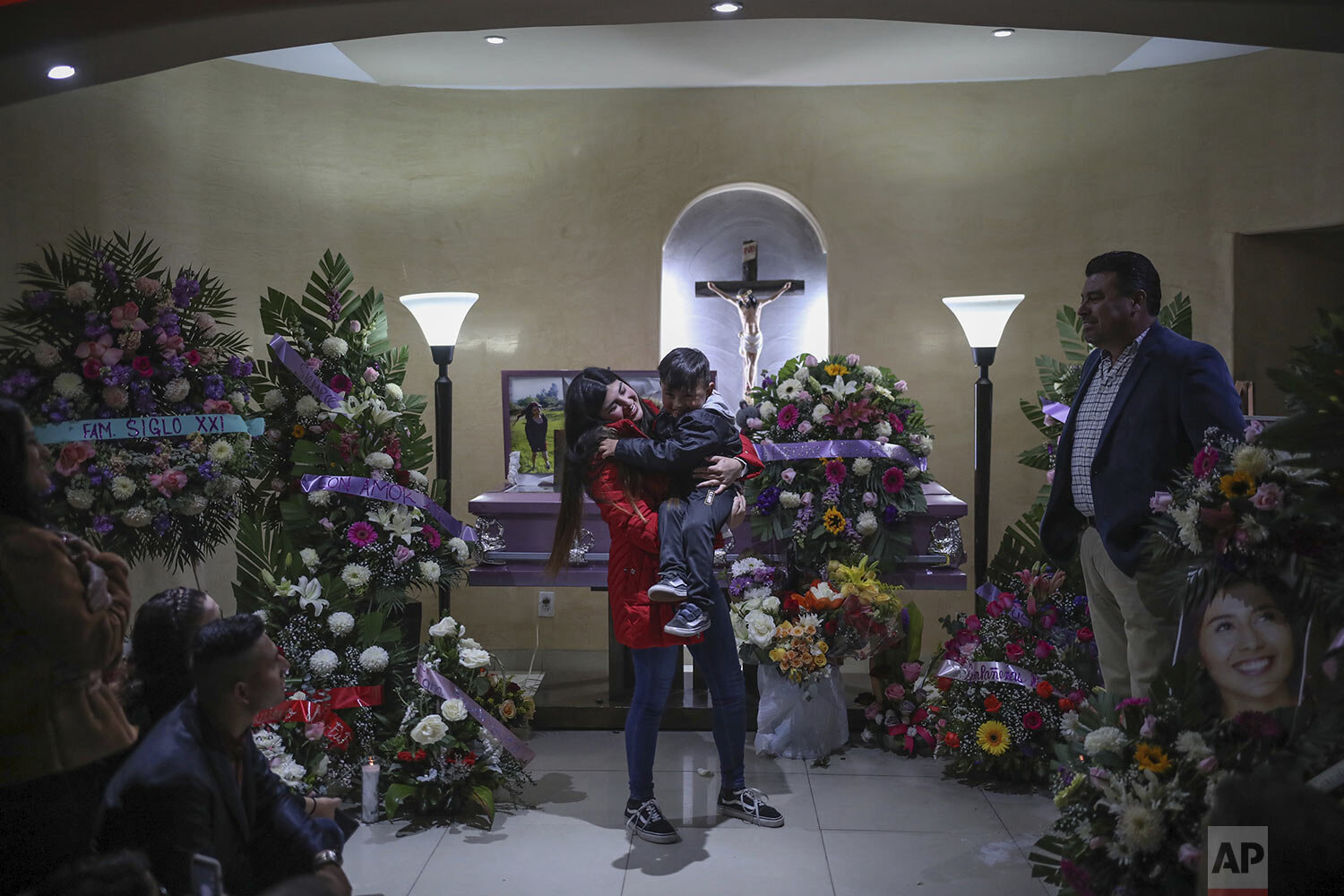  Brenda Valdez holds her son after delivering some words during the wake for her sister Marbella at a funeral home in Tijuana, Mexico, Friday, Feb. 14, 2020. (AP Photo/Emilio Espejel) 