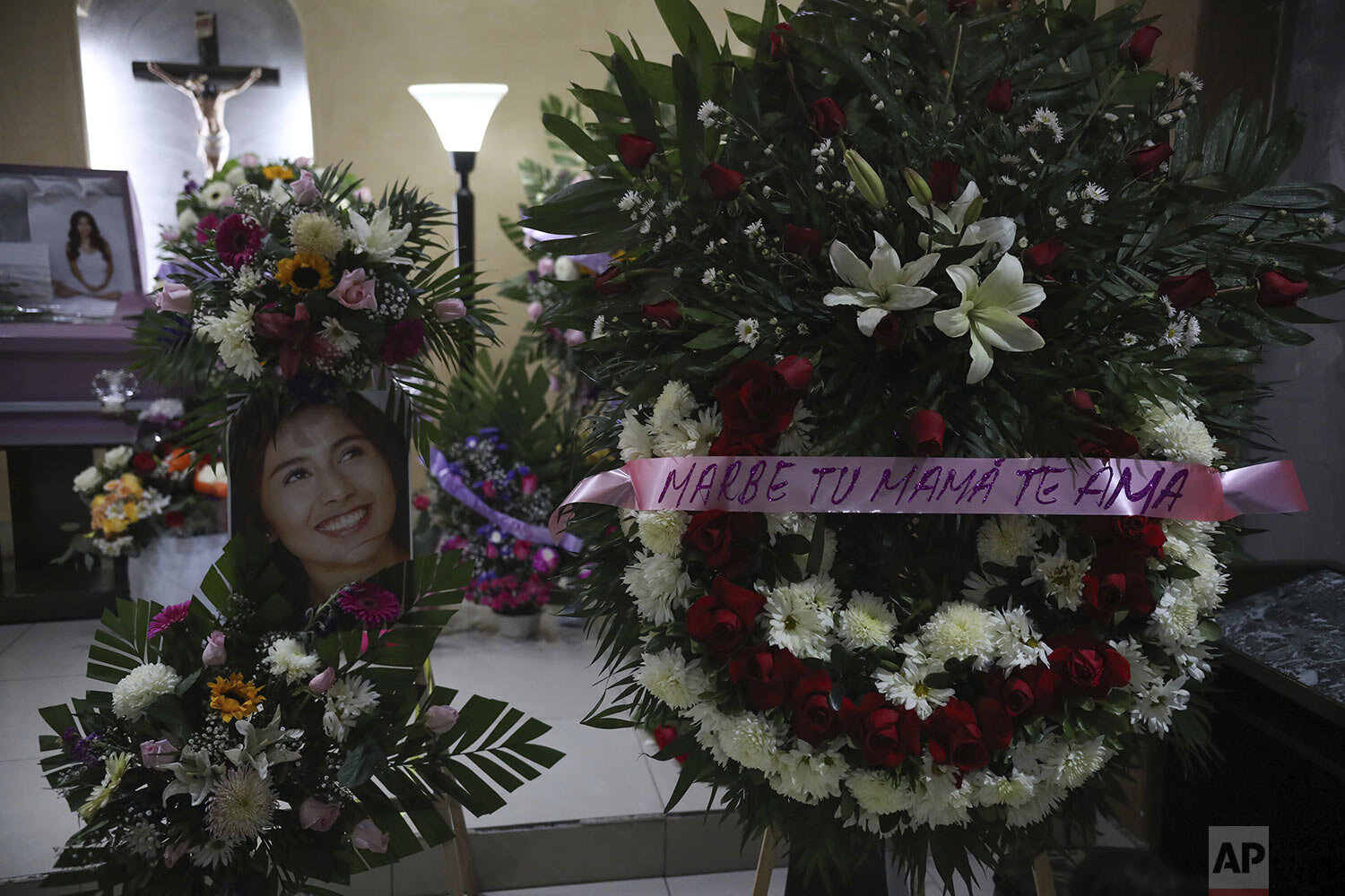  A portrait of slain woman Marbella Valdez is displayed next to a floral arrangement that reads in Spanish "Marbe, your mom loves you," next to her coffin during her wake at a funeral home in Tijuana, Mexico, Thursday, Feb. 13, 2020. (AP Photo/Emilio