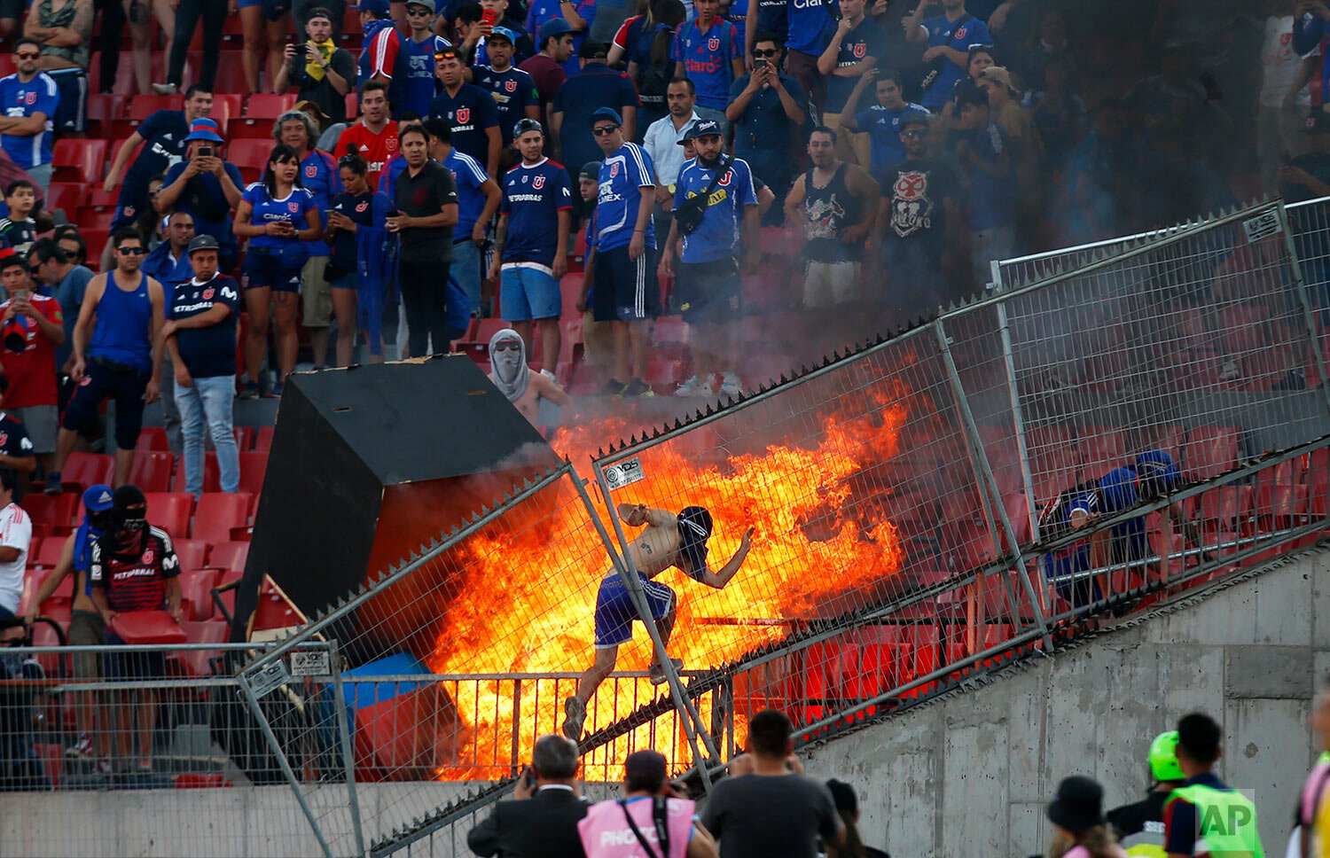  A small group of anti-government protesters set a section of the stadium on fire during the Copa Libertadores soccer game between Universidad de Chile and Brazil's SC Internacional, in Santiago, Chile, Tuesday, Feb. 4, 2020. (AP Photo/Luis Hidalgo) 