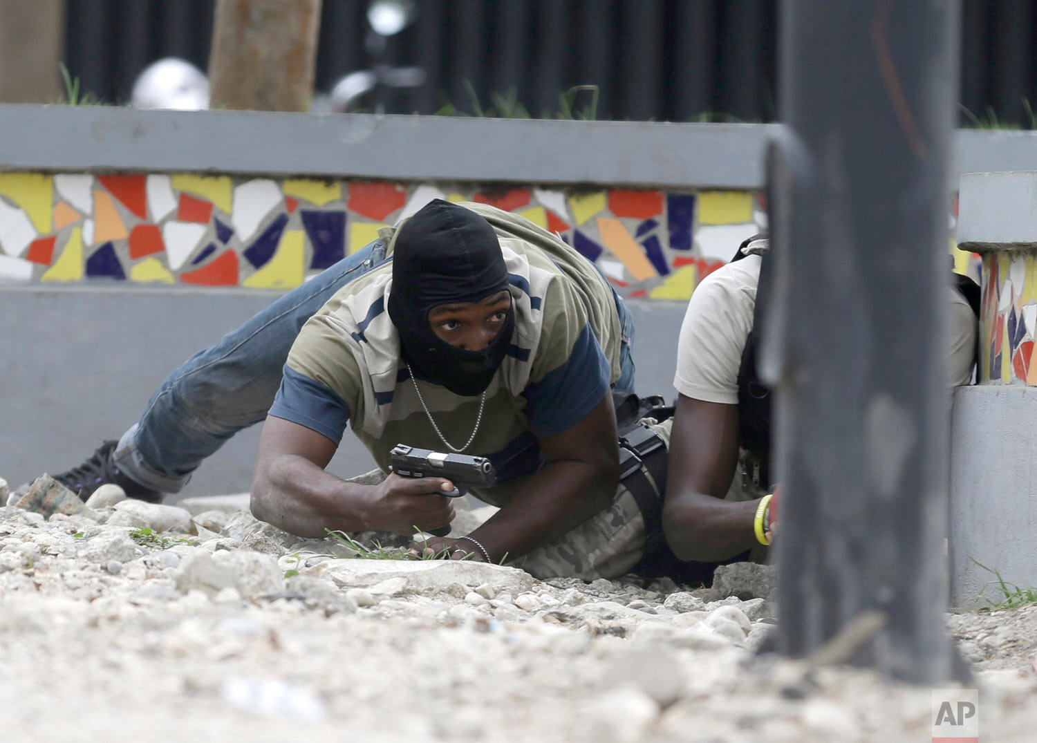  Armed off-duty police officers take cover during and exchange of gunfire with army soldiers, as they protest over police pay and working conditions, in Port-au-Prince, Haiti, Sunday, Feb. 23, 2020. (AP Photo/Dieu Nalio Chery) 