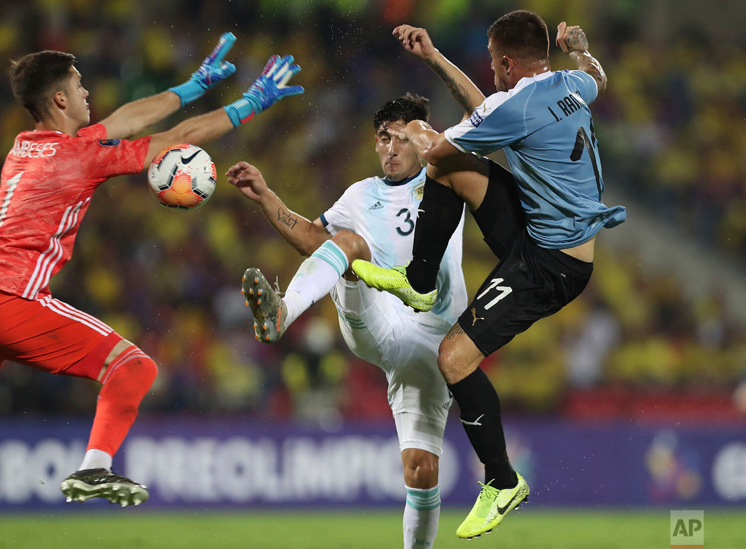  Argentina's goalkeeper Facundo Cambeses, left, and Claudio Bravo, center, battle for the ball with Uruguay's Juan Ramirez during a South America Olympic qualifying U23 soccer match at the Alfonso Lopez stadium in Bucaramanga, Colombia, Monday, Feb. 