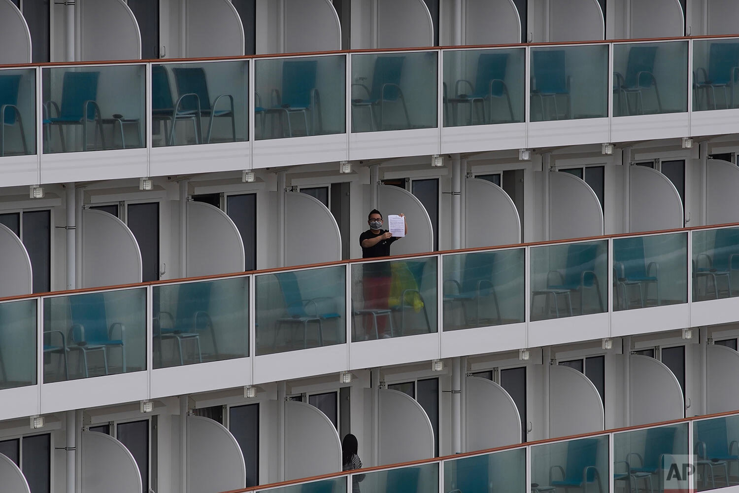 A passenger shows a note from the World Dream cruise ship docked at Kai Tak cruise terminal in Hong Kong, Wednesday, Feb. 5, 2020. (AP Photo/Vincent Yu)