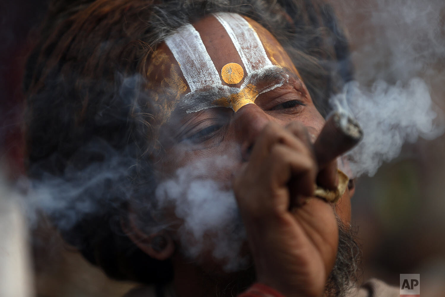 A Hindu holy man smokes marijuana at the courtyard of Pashupati temple in Kathmandu, Nepal, Thursday, Feb. 20, 2020. (AP Photo/Niranjan Shrestha)