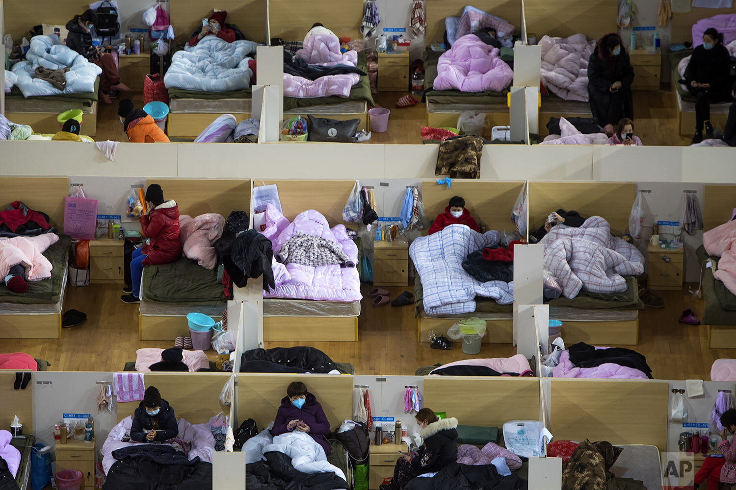 In this photo released by Xinhua News Agency, patients infected with the coronavirus take rest at a temporary hospital converted from Wuhan Sports Center in Wuhan in central China's Hubei Province, Monday, Feb. 17, 2020. (Xiao Yijiu/Xinhua via AP)