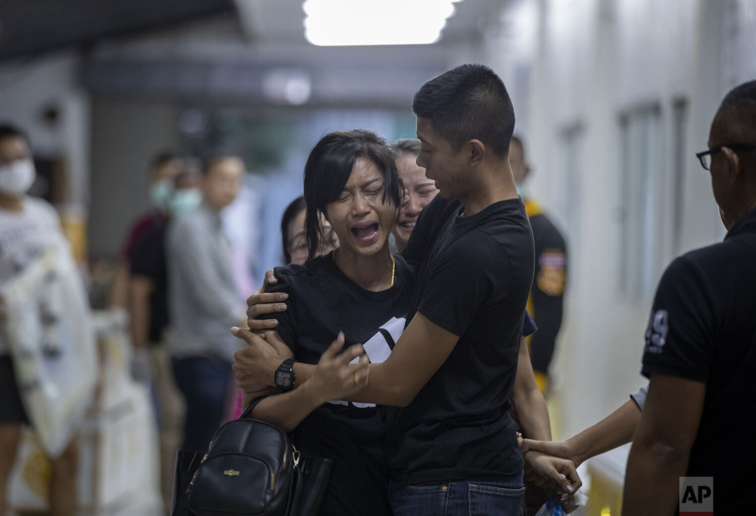 Relatives of a victim of a mass shooting react after visiting a morgue, Korat, Nakhon Ratchasima, Thailand, Sunday, Feb. 9, 2020. (AP Photo/Gemunu Amarasinghe)