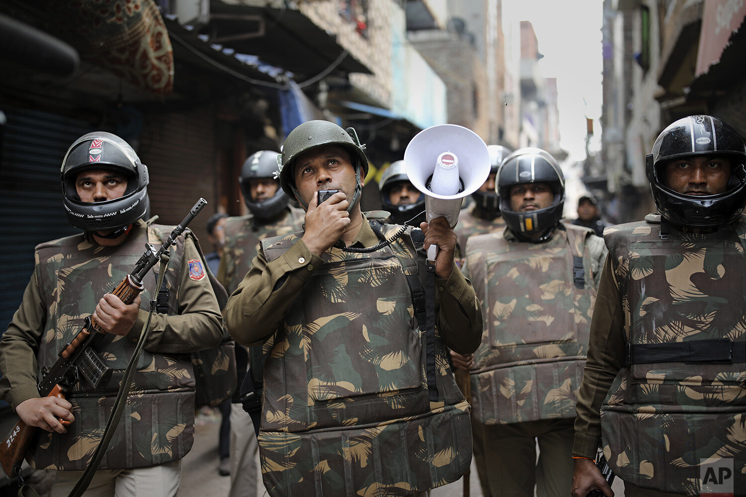  A Delhi police officer makes announcements to warn residents from venturing outside their homes as Indian security officers patrol a street in New Delhi, India, Wednesday, Feb. 26, 2020. At least 20 people were killed in three days of clashes in New