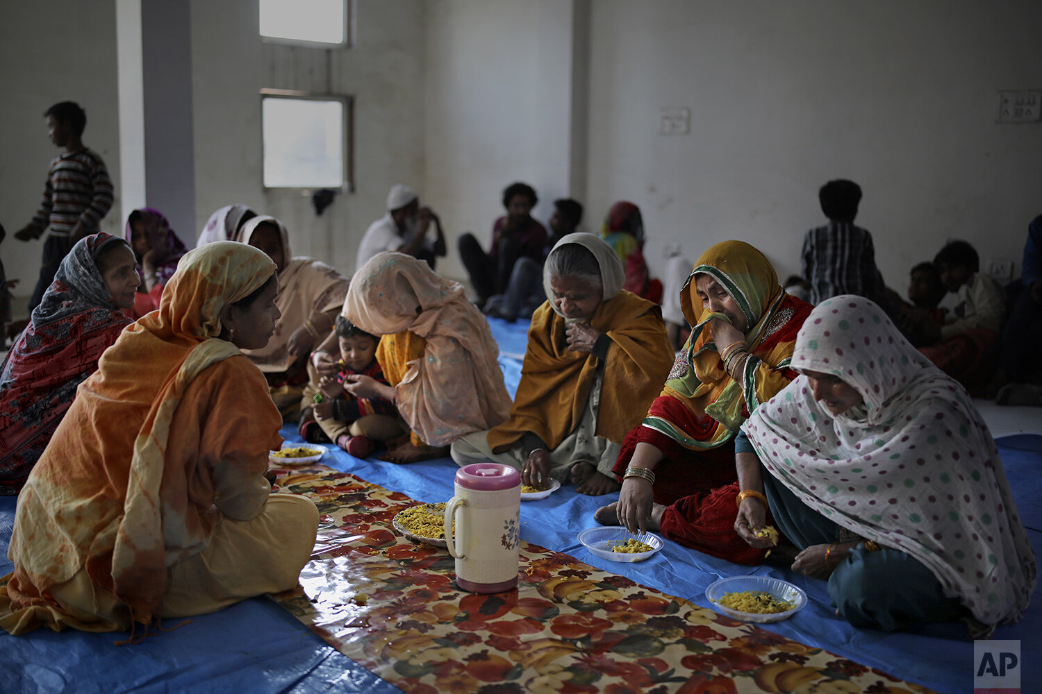 In this Friday, Feb. 28, 2020 photo, Muslim women, who were rescued after their homes were attacked by a marauding Hindu mob, sob while eating a meal inside a hall which doubles as a shelter at Al-Hind hospital in Old Mustafabad neighborhood of New 