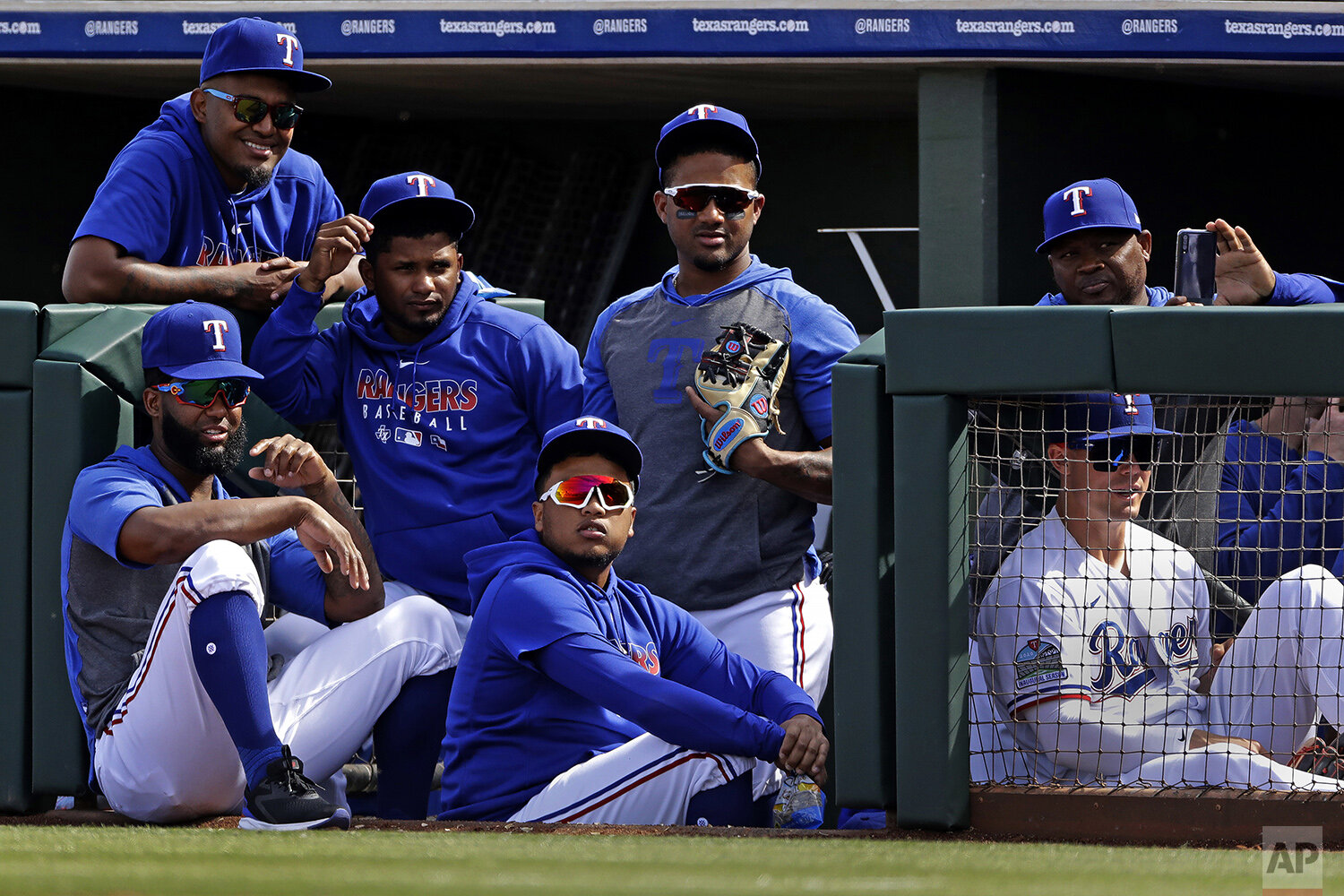  Texas Rangers players watch from the dugout during the second inning of a spring training baseball game against the Chicago Cubs Thursday, Feb. 27, 2020, in Surprise, Ariz. (AP Photo/Charlie Riedel) 