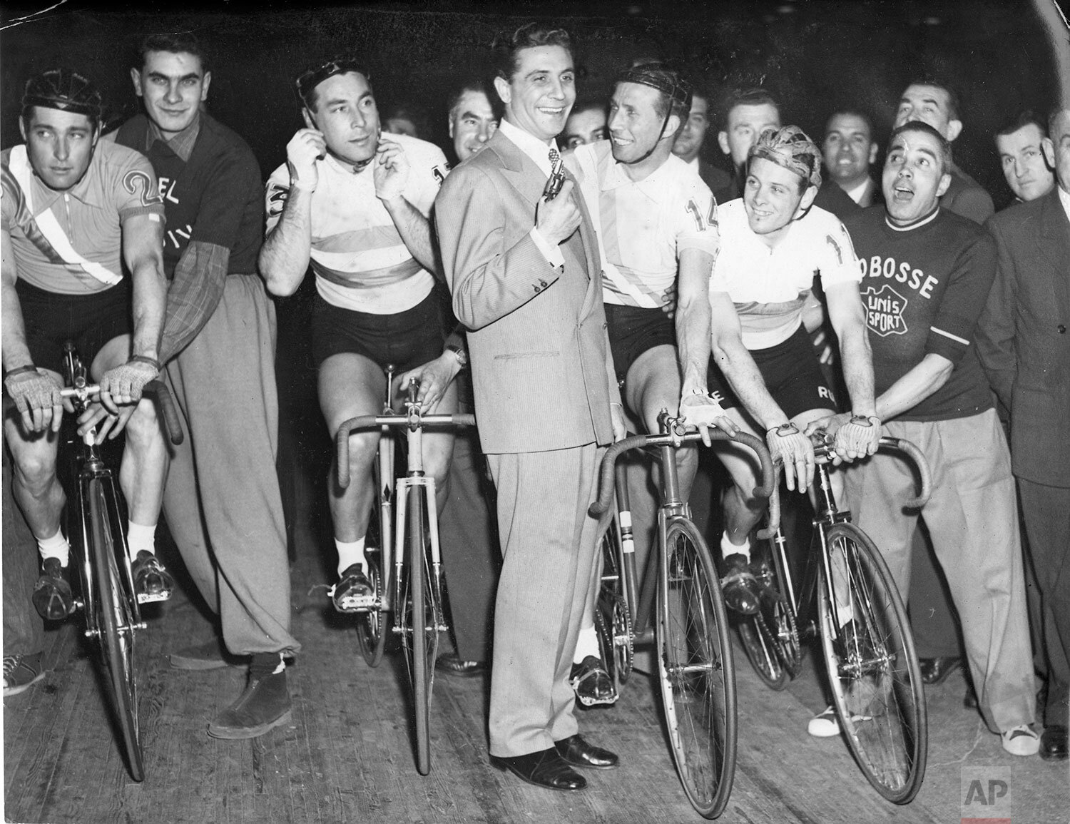  Popular French singer, composer and actor Gilbert Becaud fires off the classic Six Day bicycle race at velodrome d'Hiver of Paris, France, April 2, 1955. From left to right: Raymond Goussot, Georges Senffleben, Gilbert Becaud holding his pistol and 
