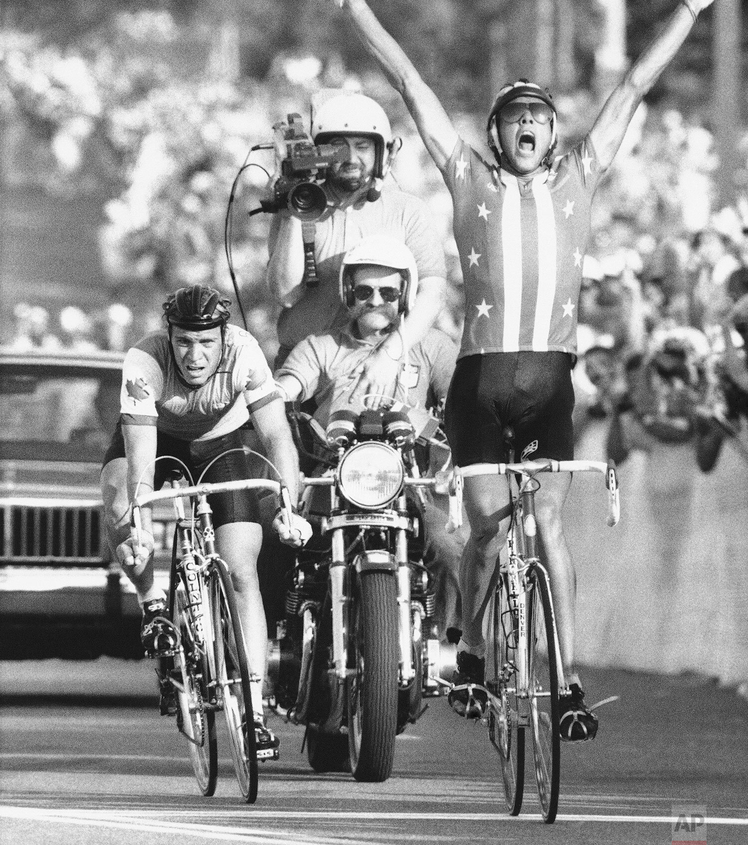  Alexis Grewal of Aspen Colorado, right, raises his hands in victory July 29, 1984, as he crosses the finish of the Olympic 190-kilometer road race just ahead of Canada's Steve Bauer, left, in Mission Viejo, California. (AP Photo/Lionel Cironneau) 