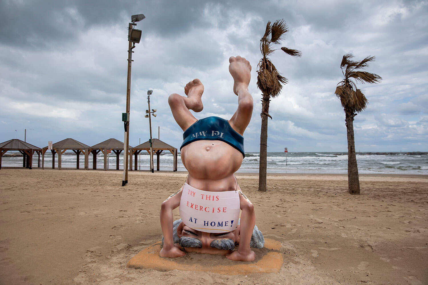  A sign calling people to stay home to reduce the spread of the new coronavirus is placed on a statue of the first Israeli Prime Minister David Ben Gurion at a beach in Tel Aviv, Israel, March 20, 2020. (AP Photo/Oded Balilty) 