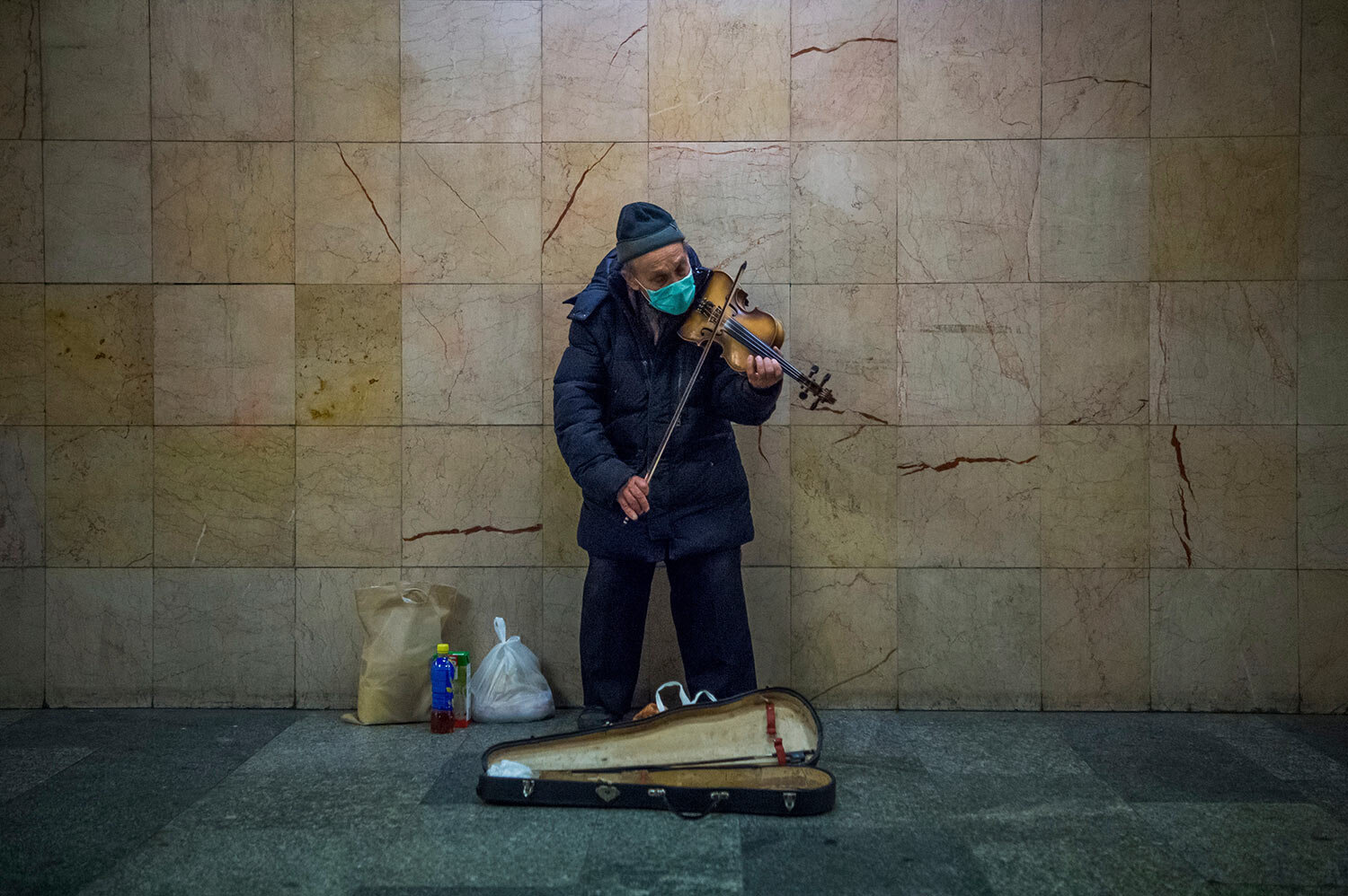  Busker wearing a protective face mask plays the violin in the subway at Nyugati Square during the coronavirus emergency in Budapest, Hungary, March 18, 2020. (Zoltan Balogh/MTI via AP) 