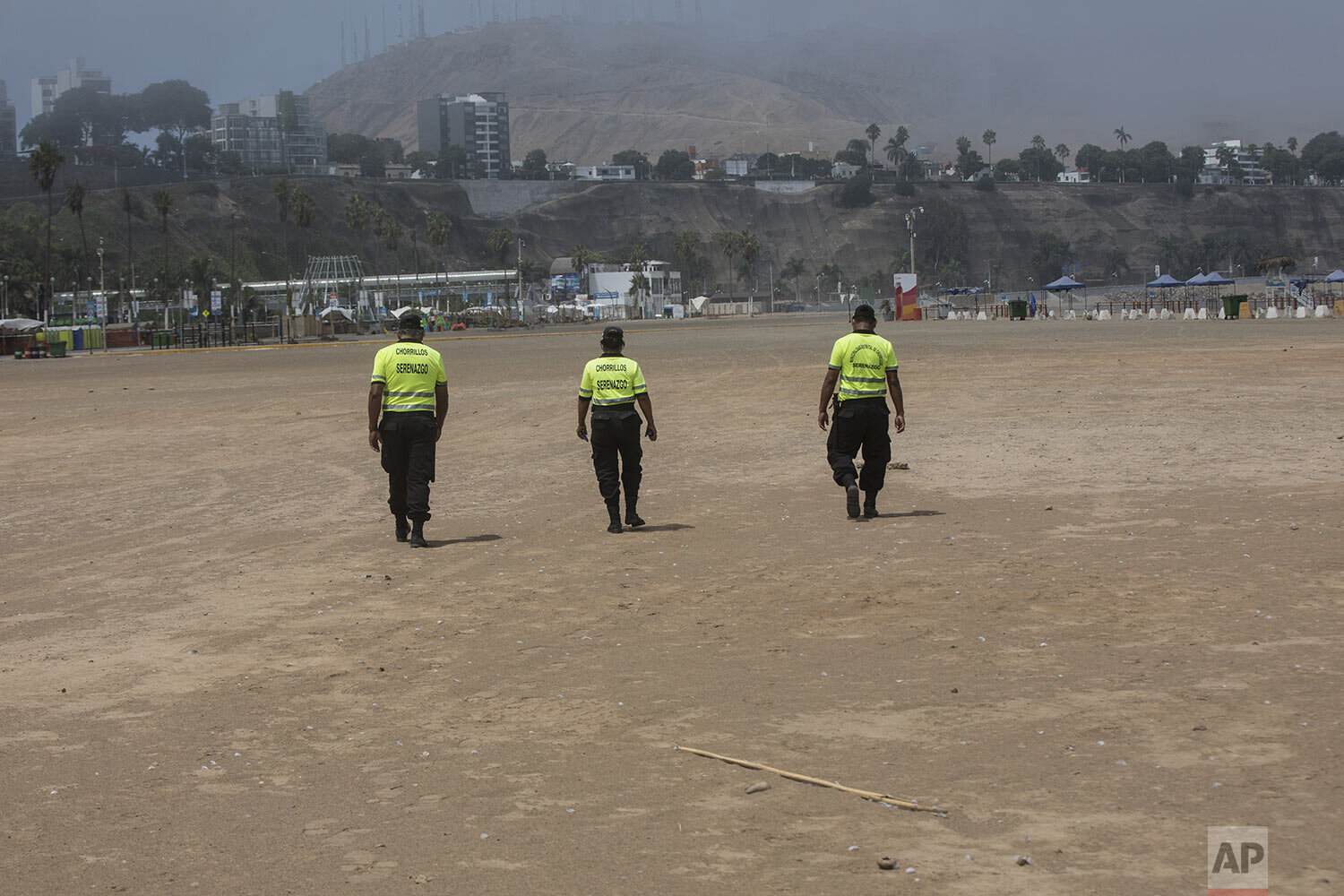  Policemen walk along an empty shore on the final days of the Southern Hemisphere summer to warn off would be swimmers as a precaution to contain the spread of the new coronavirus, at Agua Dulce beach in Lima, Peru, March 24, 2020. (AP Photo/Rodrigo 