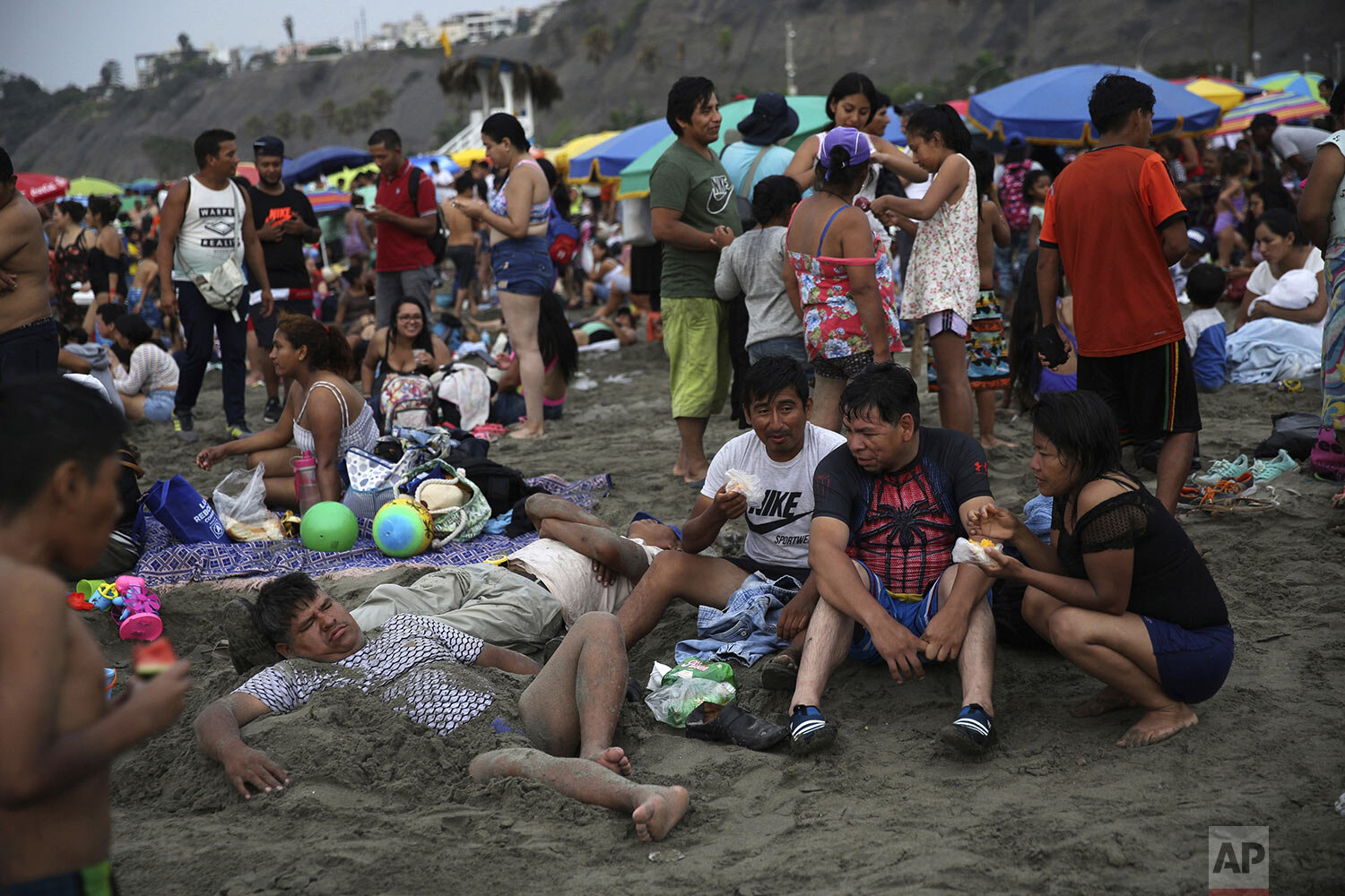  Beachgoers relax in the sand at Agua Dulce beach in Lima, Peru, Feb. 16, 2020. (AP Photo/Rodrigo Abd) 