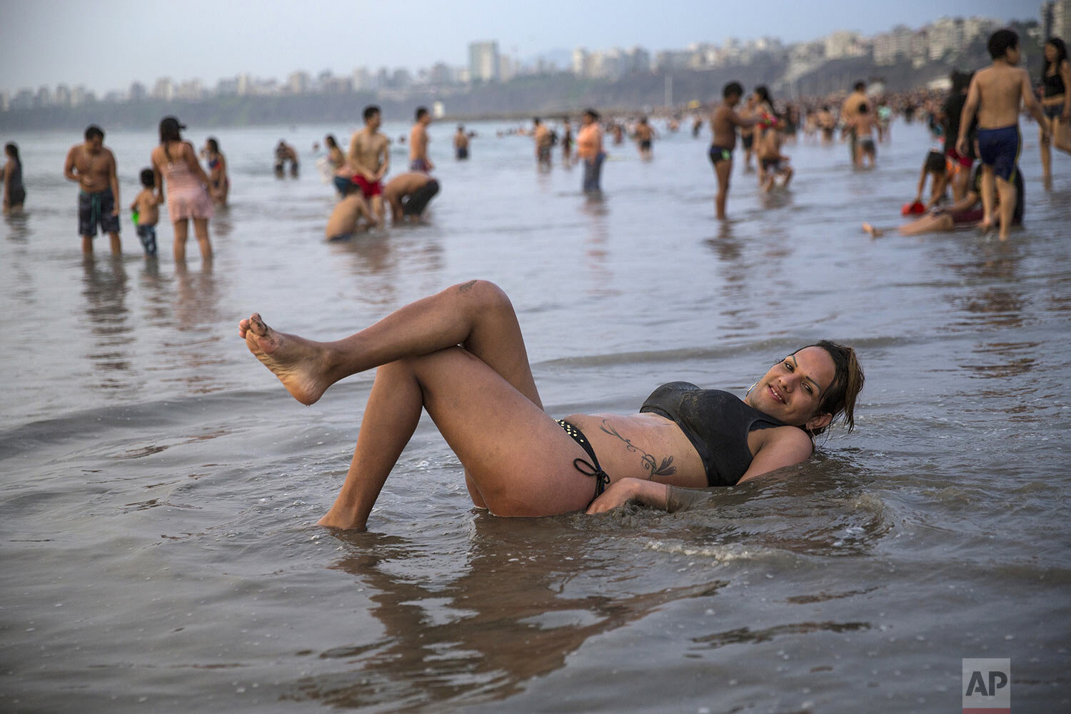  Transgender Natalia, a Venezuelan migrant, strikes a pose as she wades in shallow waters along the shore of Agua Dulce beach in Lima, Peru, Feb. 16, 2020. (AP Photo/Rodrigo Abd) 