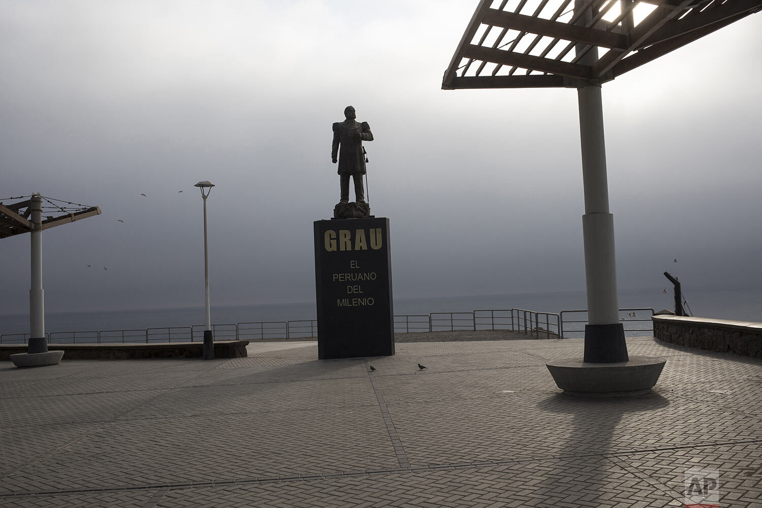  A statue of Peruvian naval hero Miguel Grau overlooks the Pacific coast on the normally popular boardwalk usually filled with visitors, in Lima, Peru, March 25, 2020. (AP Photo/Rodrigo Abd) 