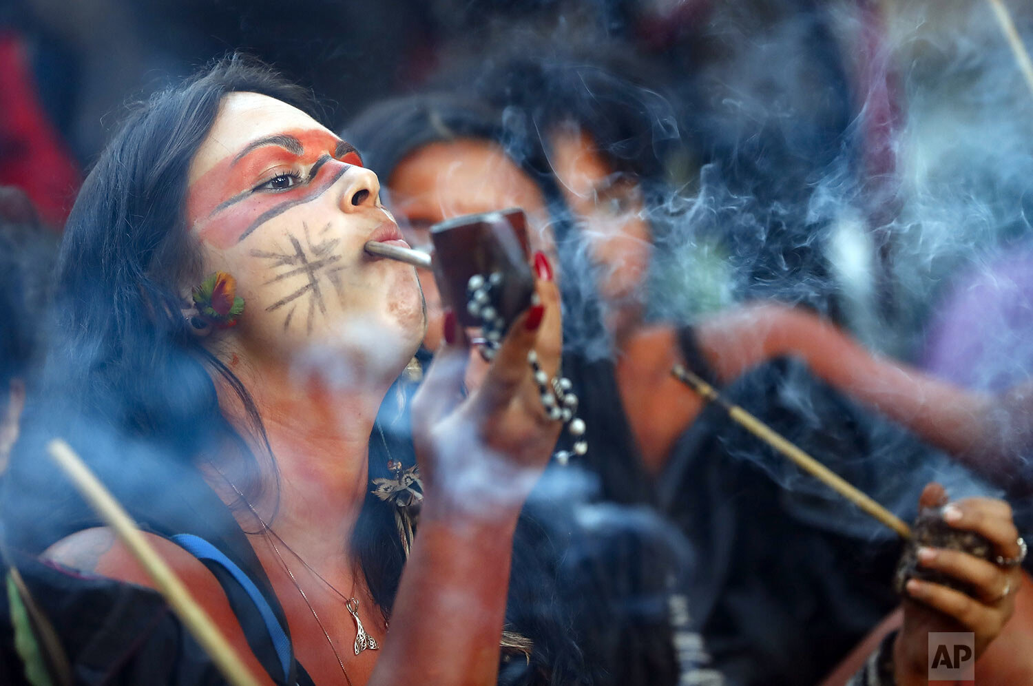  A Guarani Mbya indigenous woman smokes a pipe while waiting for police to enter the property her community has been occupying in an attempt to stop real estate developer Tenda from constructing apartment buildings next to their land in Sao Paulo, Br