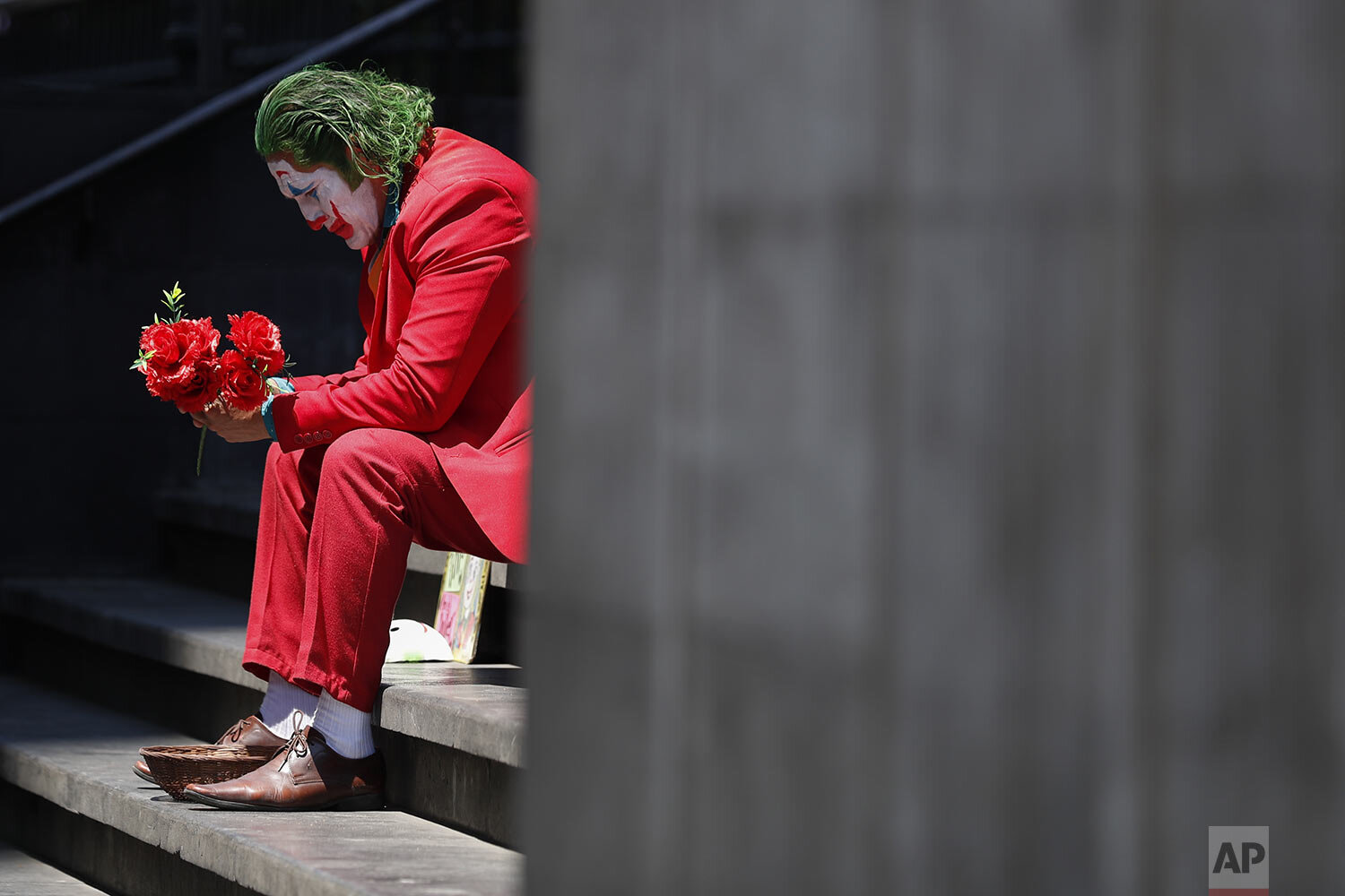  David Vazquez, a street performer dressed as the Joker, waits in hopes of pedestrians who will pay to take pictures with him in Mexico City, March 23, 2020. Vazquez, who also worked as a trainer in a gym until it shut down today, said business for s