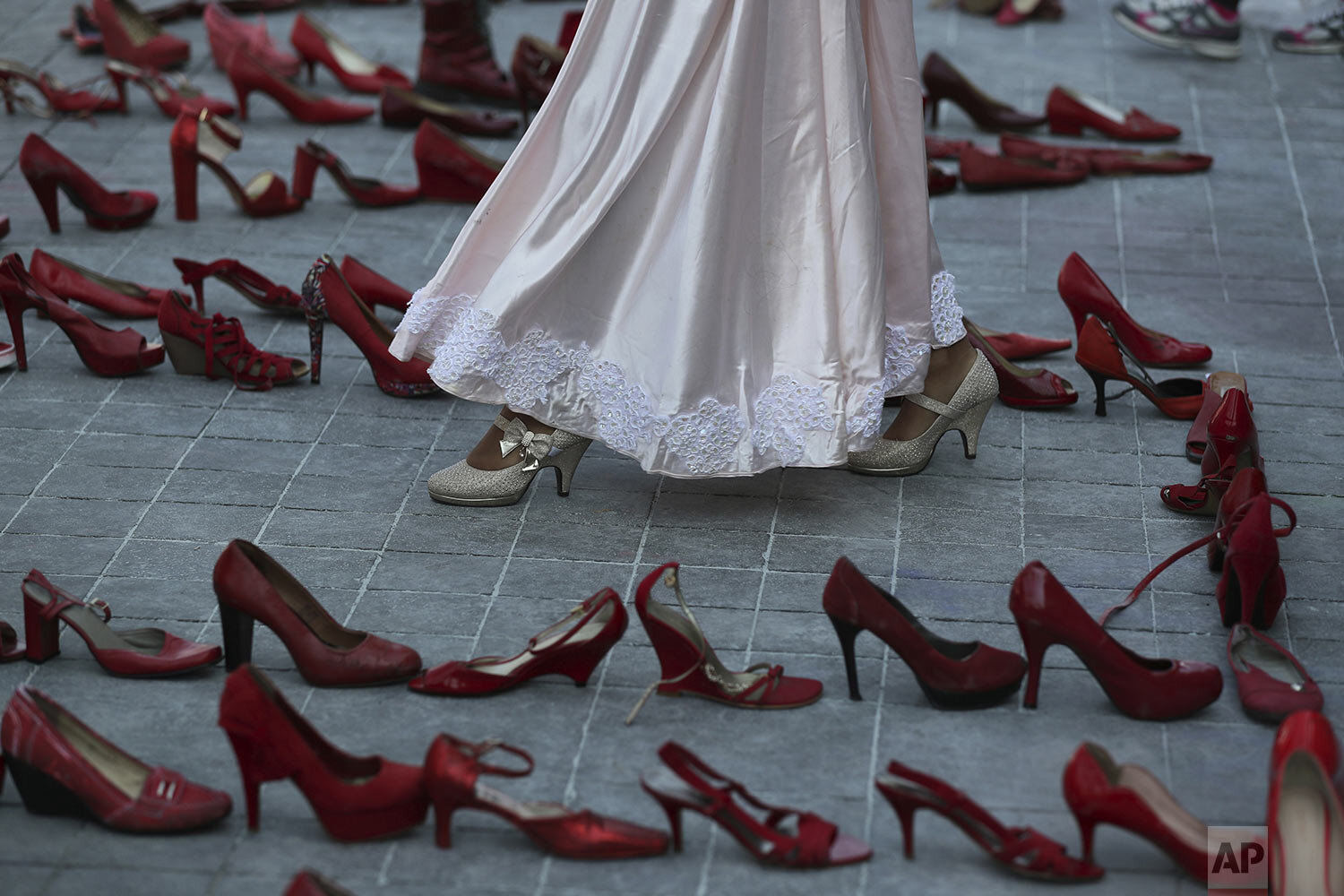 An actress walks amid red shoes representing murdered women during a performance on International Women's Day, coined "A Day Without Women" in Mexico City, March 9, 2020. Women across Mexico went on strike to protest rampant gender violence. (AP Pho