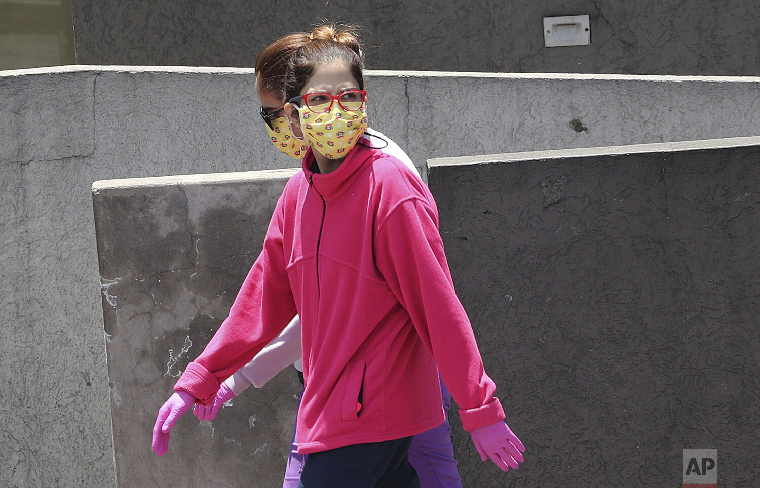  Women wear face masks and gloves as a precaution against the spread of the new coronavirus, in Quito, Ecuador, March 19, 2020. (AP Photo/Dolores Ochoa) 