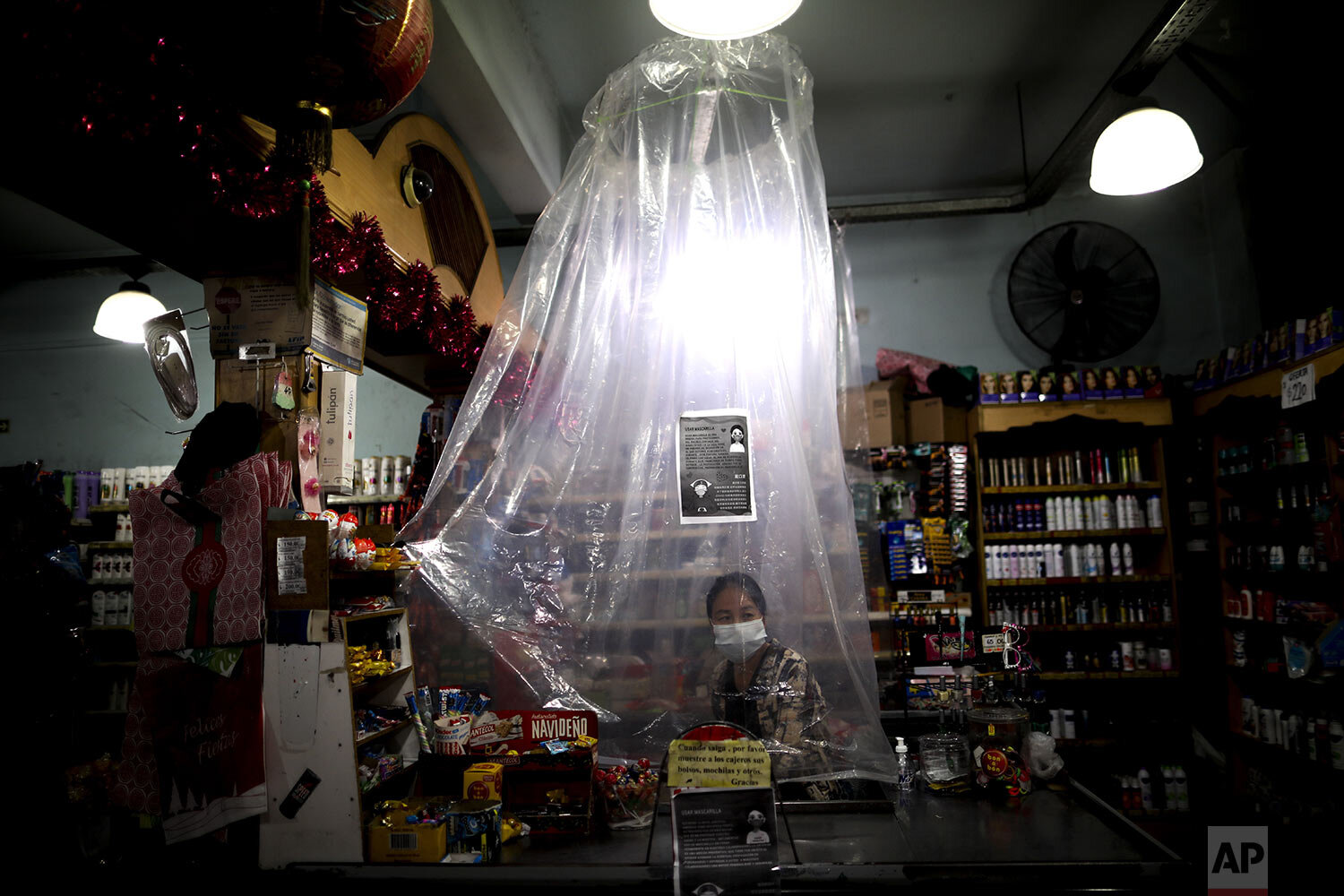  A supermarket cashier waits for costumers behind a plastic curtain as a precaution against the spread of the new coronavirus, in Buenos Aires, Argentina, March 16, 2020. (AP Photo/Natacha Pisarenko) 