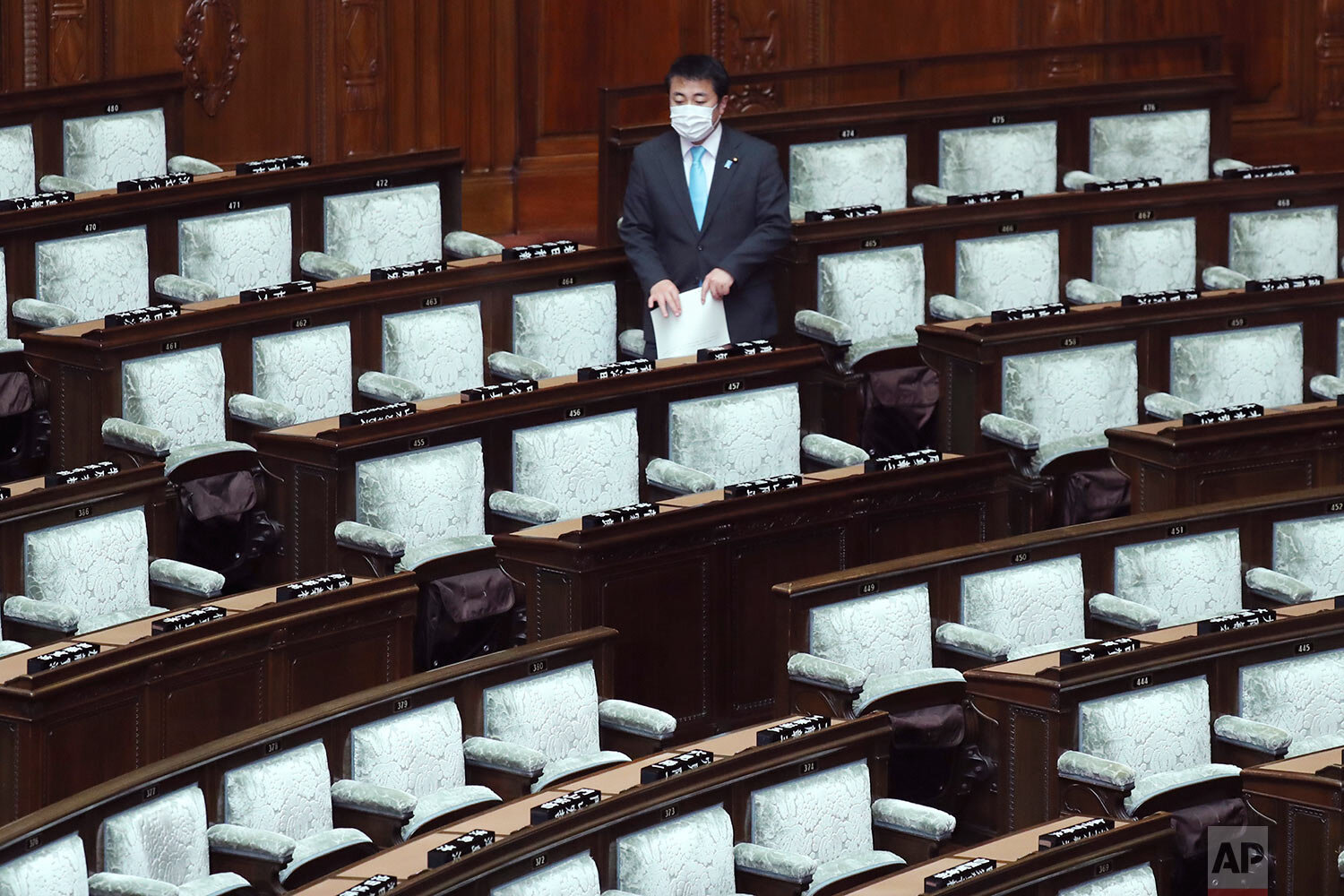  A lawmaker wearing a face mask arrives for a plenary session at the lower house of parliament in Tokyo, Thursday, March 12, 2020. (AP Photo/Koji Sasahara) 