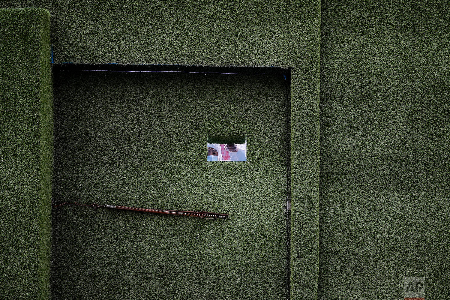  A security guard wearing protective gear peeks out from an entrance gate of a construction site at the Central Business District following the coronavirus outbreak in Beijing, Monday, March 2, 2020. (AP Photo/Andy Wong) 