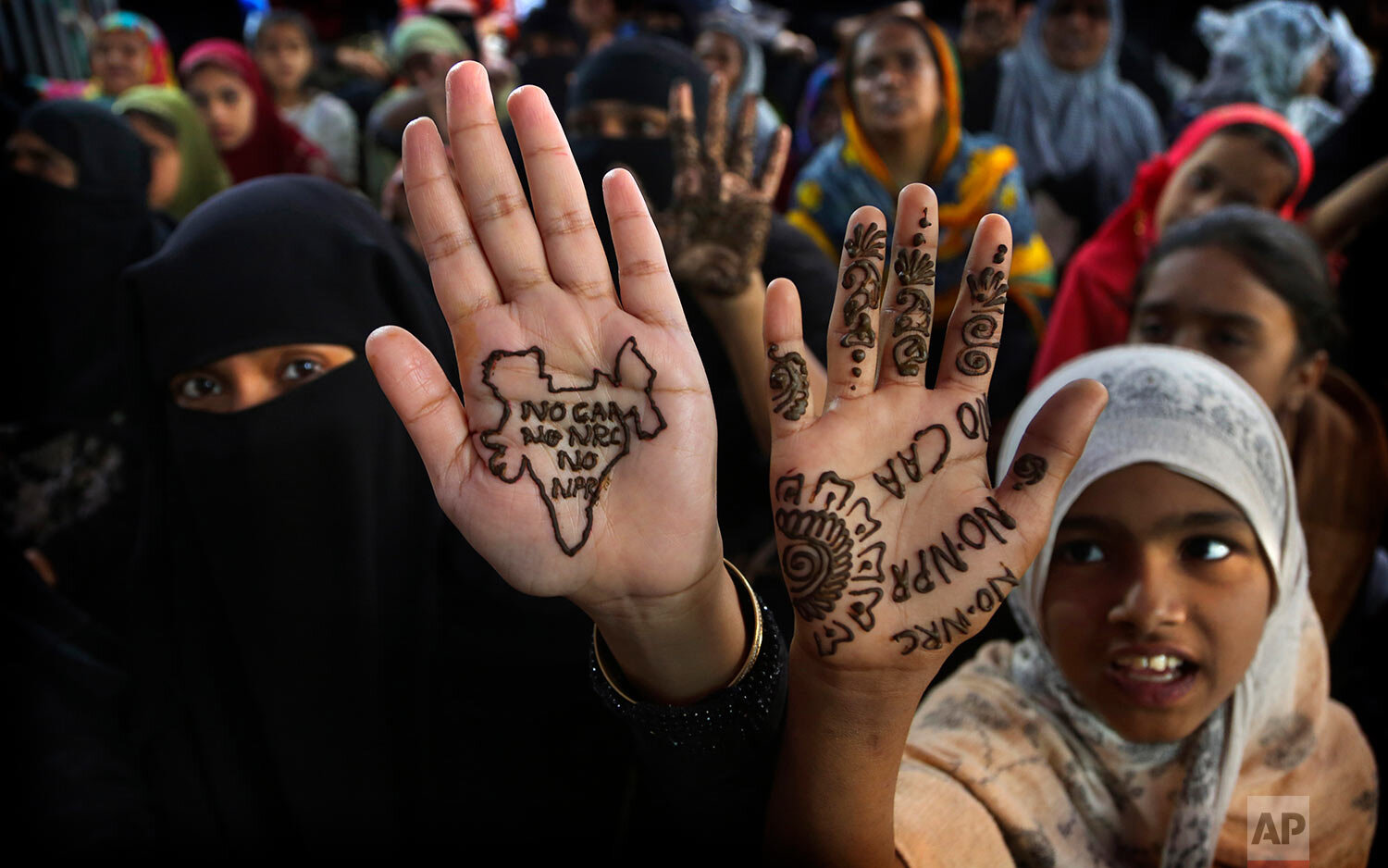 Indian women and children display slogans written with henna on their palms during a protest against a new citizenship law in Bangalore, India, Sunday, March 1, 2020. (AP Photo/Aijaz Rahi) 