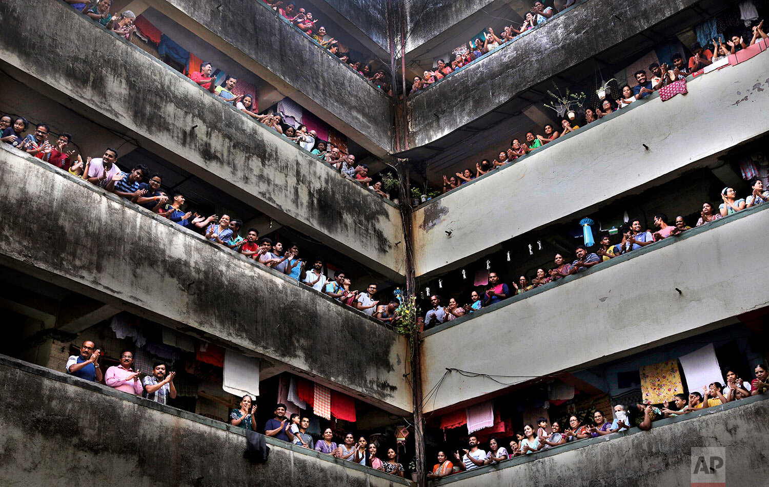  People clap from balconies in show of appreciation to health care workers at a Chawl in Mumbai, India, Sunday, March 22, 2020.  (AP Photo/Rafiq Maqbool) 