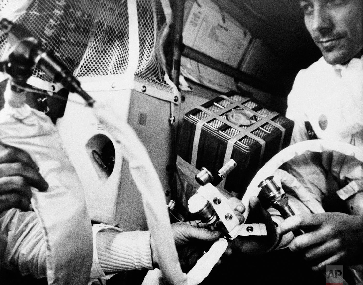  In this image provided by NASA, Apollo 13 command module pilot John L. Swigert Jr., and another crewman, start to hook up the lithium hydroxide canister in the lunar module April 20, 1970, in an effort to get rid of carbon dioxide in the cabin as th