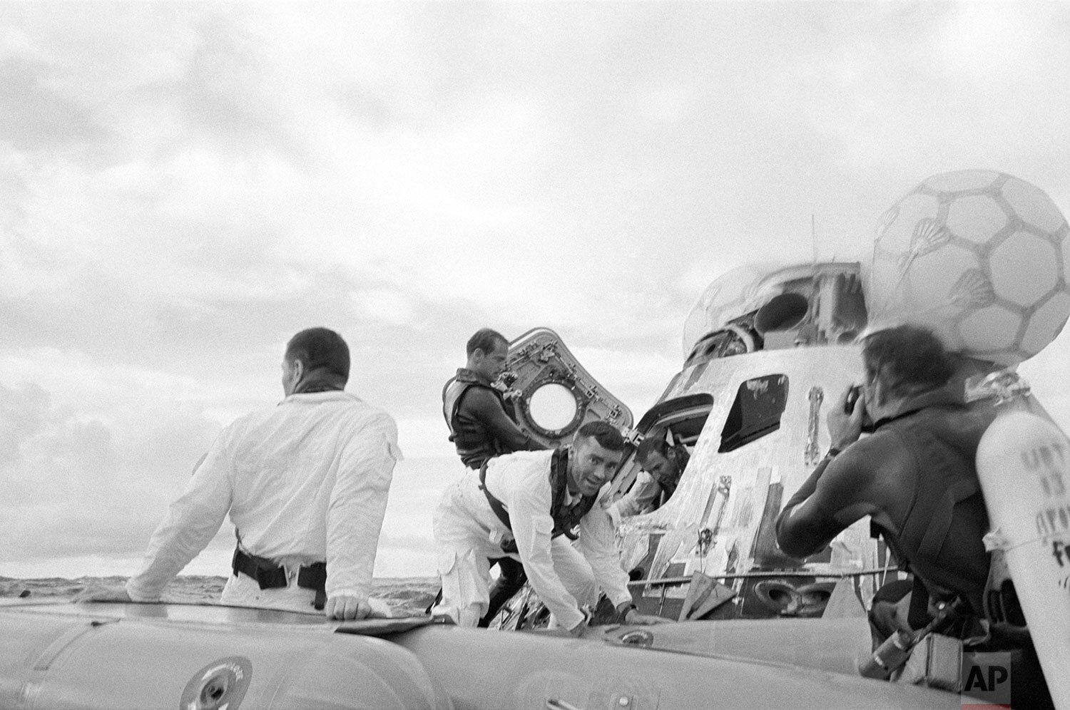  A water level view of the Apollo 13 recovery operations in the South Pacific Ocean, April 17, 1970. The three astronauts are seen leaving their spacecraft. John L. Swigert Jr. (back to camera), command module pilot, is already in the life raft. Fred