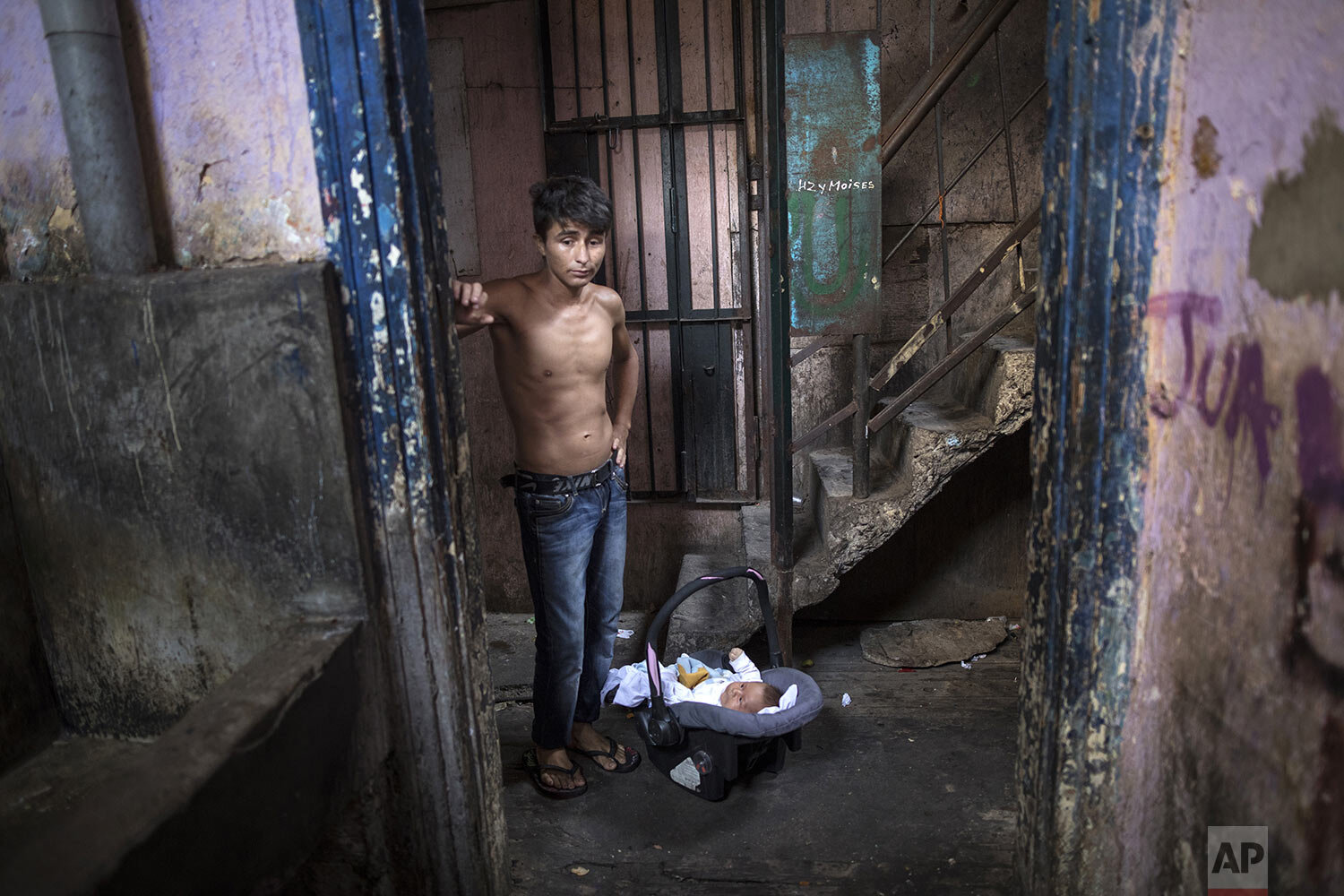  In this April 3, 2020 photo, ex-convict Julio Ramos stands next to his 3-month-old son Jose, inside the deteriorating building where he lives nicknamed “Luriganchito,” after the country’s most populous prison, in Lima, Peru. “I do not want my childr