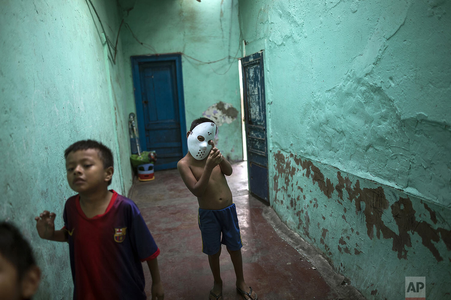  In this March 24, 2020 photo, children, one wearing a Jason Halloween mask, play inside the deteriorated house where they live nicknamed “Luriganchito,” after the country’s most populous prison, in Lima, Peru. (AP Photo/Rodrigo Abd) 