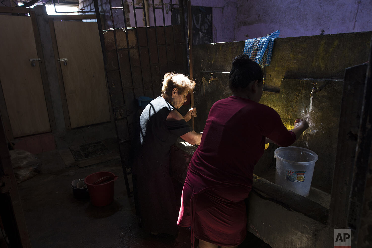  In this March 23, 2020 photo, Maria Isabel Aguinaga washes her clothes in a communal laundry area of a deteriorating building nicknamed “Luriganchito,” after the country’s most populous prison, in Lima, Peru. (AP Photo/Rodrigo Abd) 