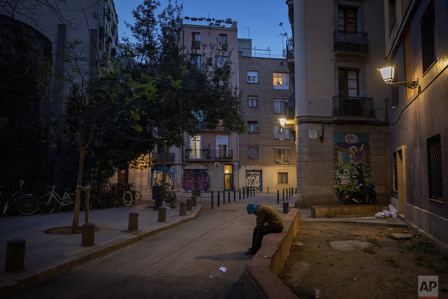  In this Friday, March 20, 2020, Gana Gutierrez sits in an empty street in Barcelona, Spain. ???It is as if there has been a nuclear explosion and they are all sheltering in the bunker. Only us, the homeless, are left out " explains 36-year-old Gana,